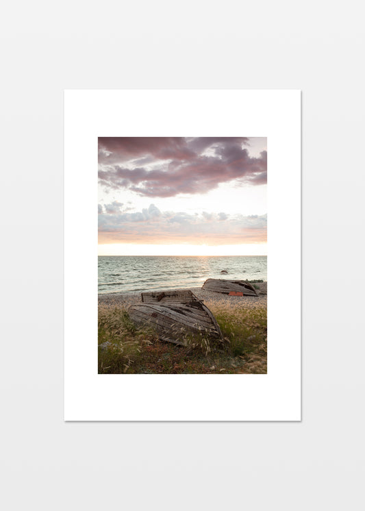 Gamle træbåde på stranden ved solnedgang på Gotland.